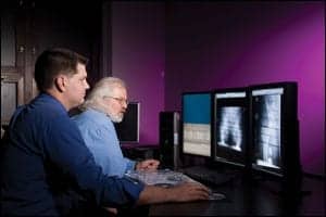 Richard Ivnik, chief biomedical engineer, left; and Paul Sherman troubleshoot the PACS monitors.