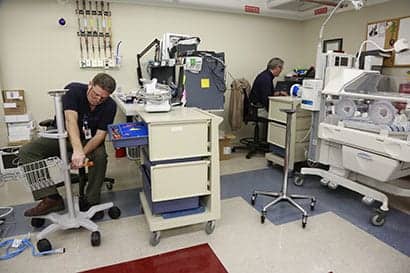 Bill Adney, left, repairs a noninvasive blood pressure stand while Bill Zilk  works on the medical equipment database.